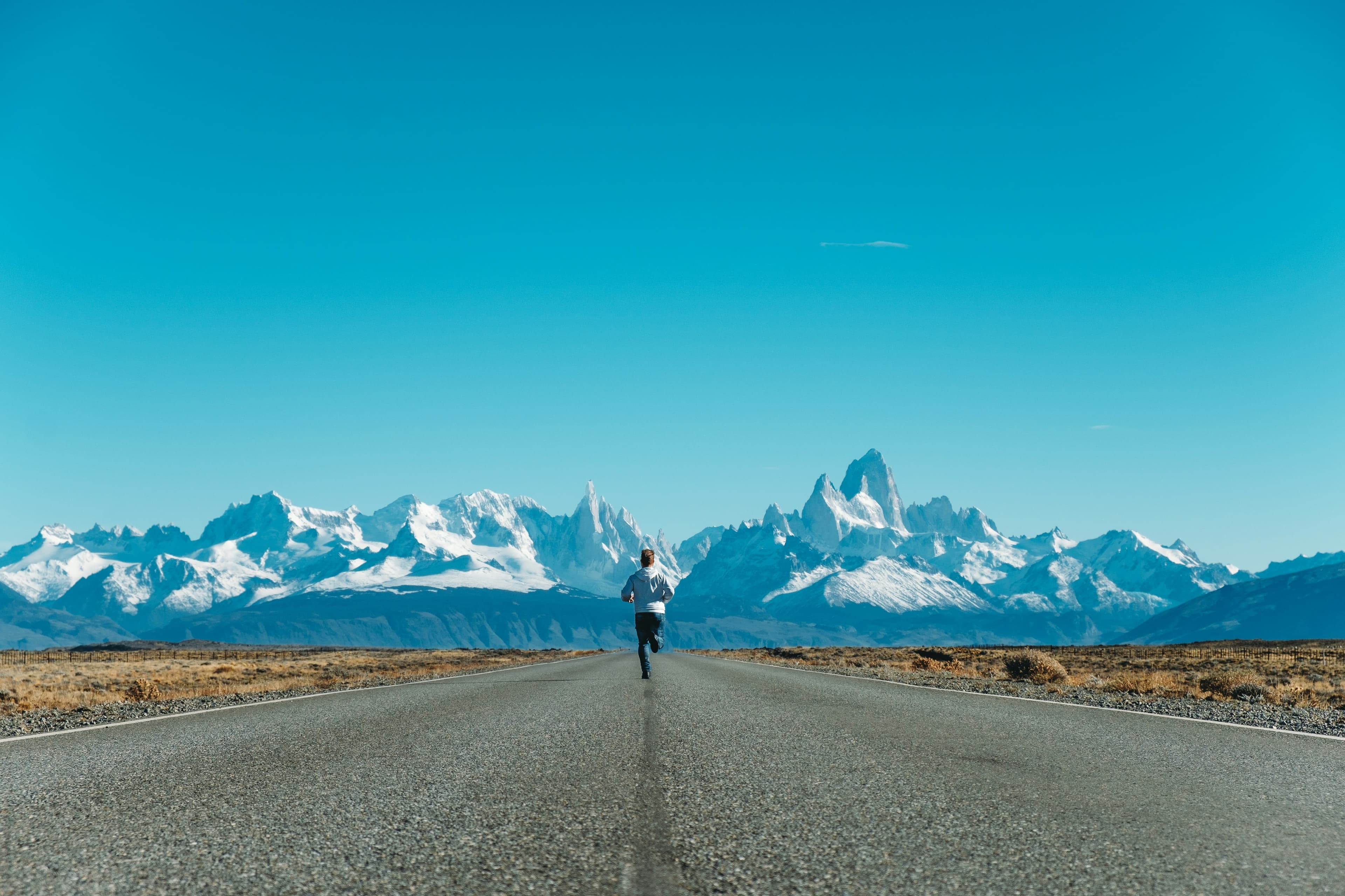 Runner mid-stride toward the mountains.