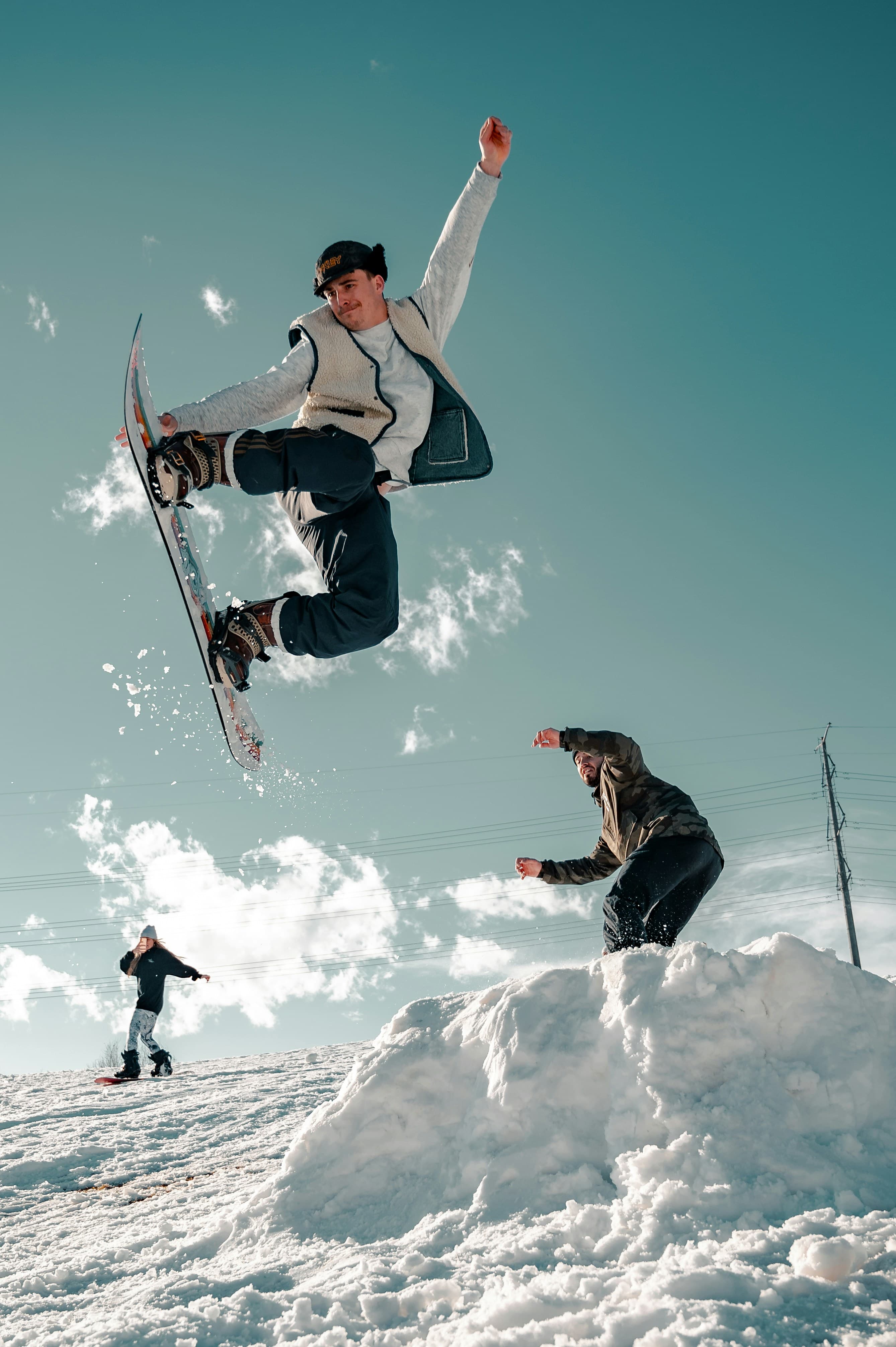 Snowboarder mid-air off a powder lip.